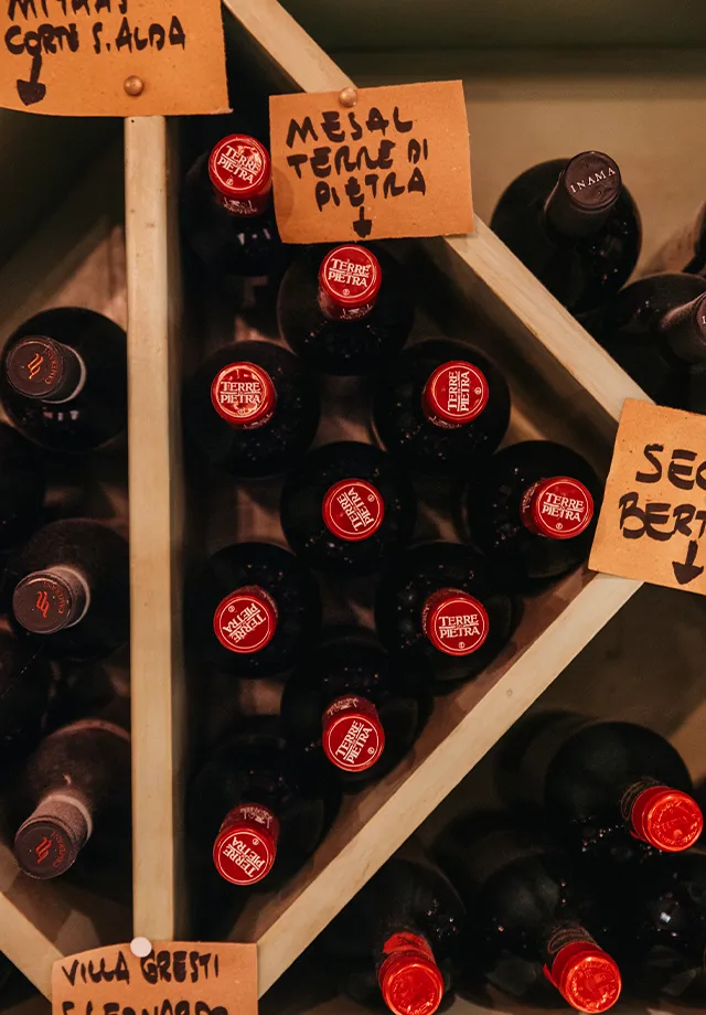 Primo piano di una delle mensole che ospitano i vini rossi del territorio