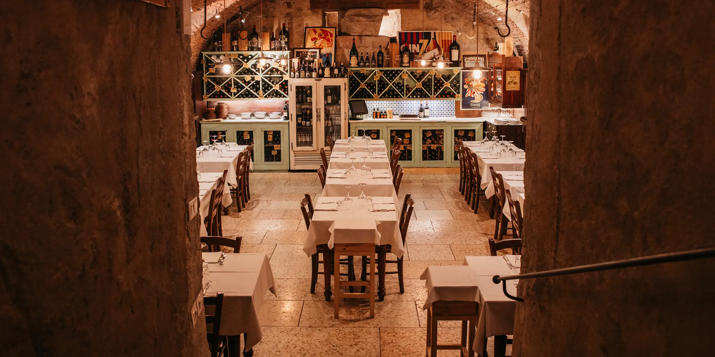 La cantina della taverna con soffitto a botte in mattoni originali e tavoli apparecchiati